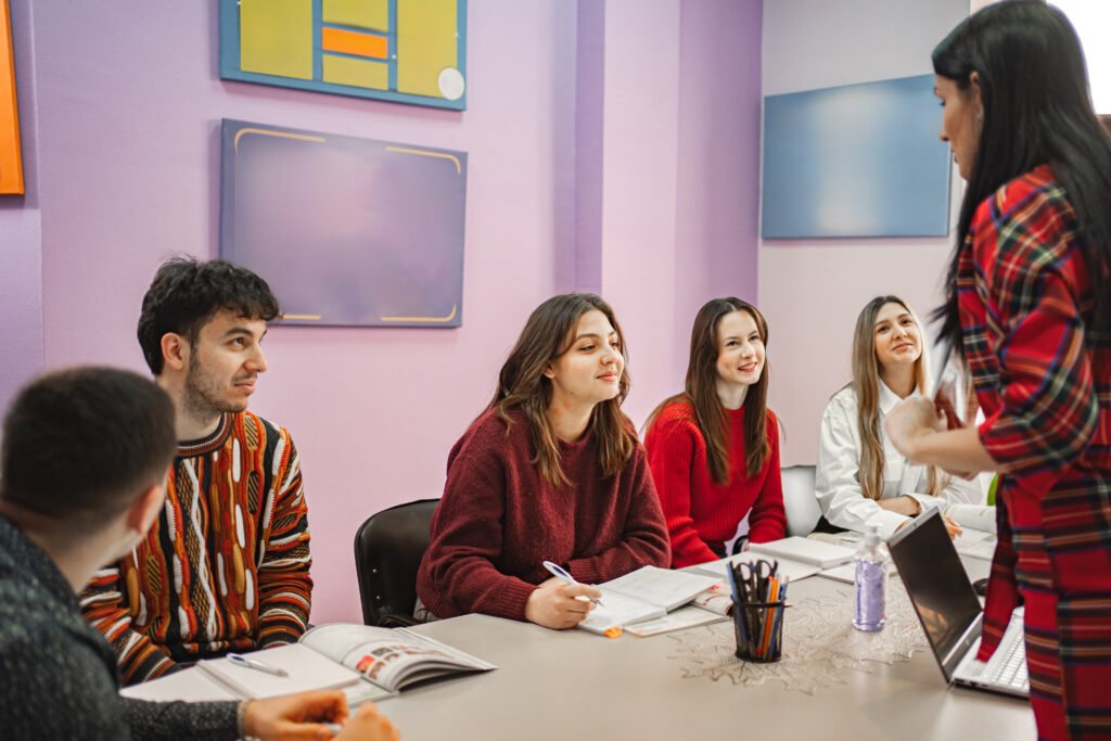 female teacher explaining subject to her teenage students at language school