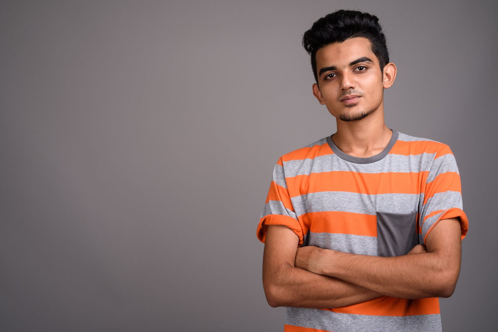young indian man against gray background